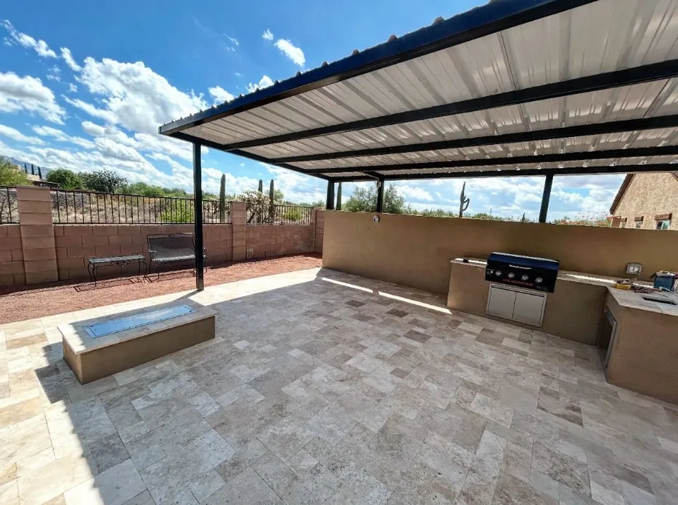 Built-in griddle on a light stone patio, with a low fire feature in front.